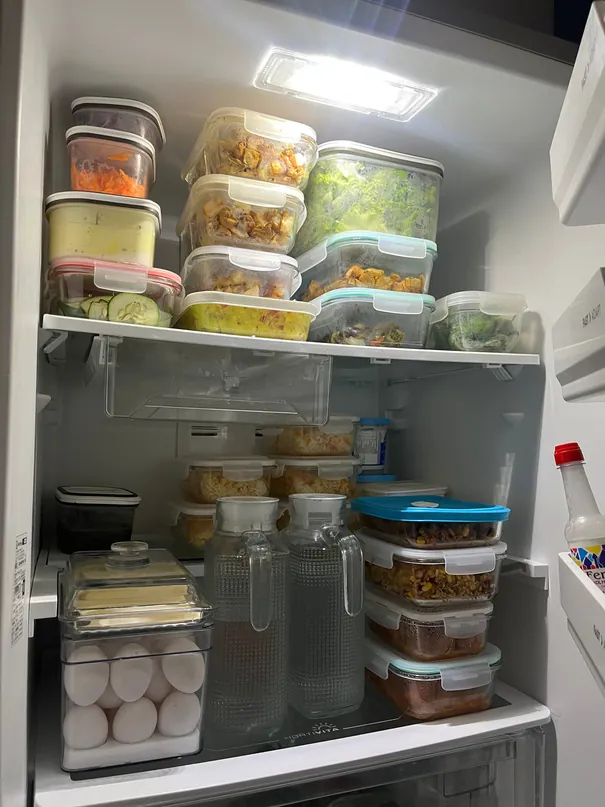 Prateleiras da geladeira com potes de comida caseira